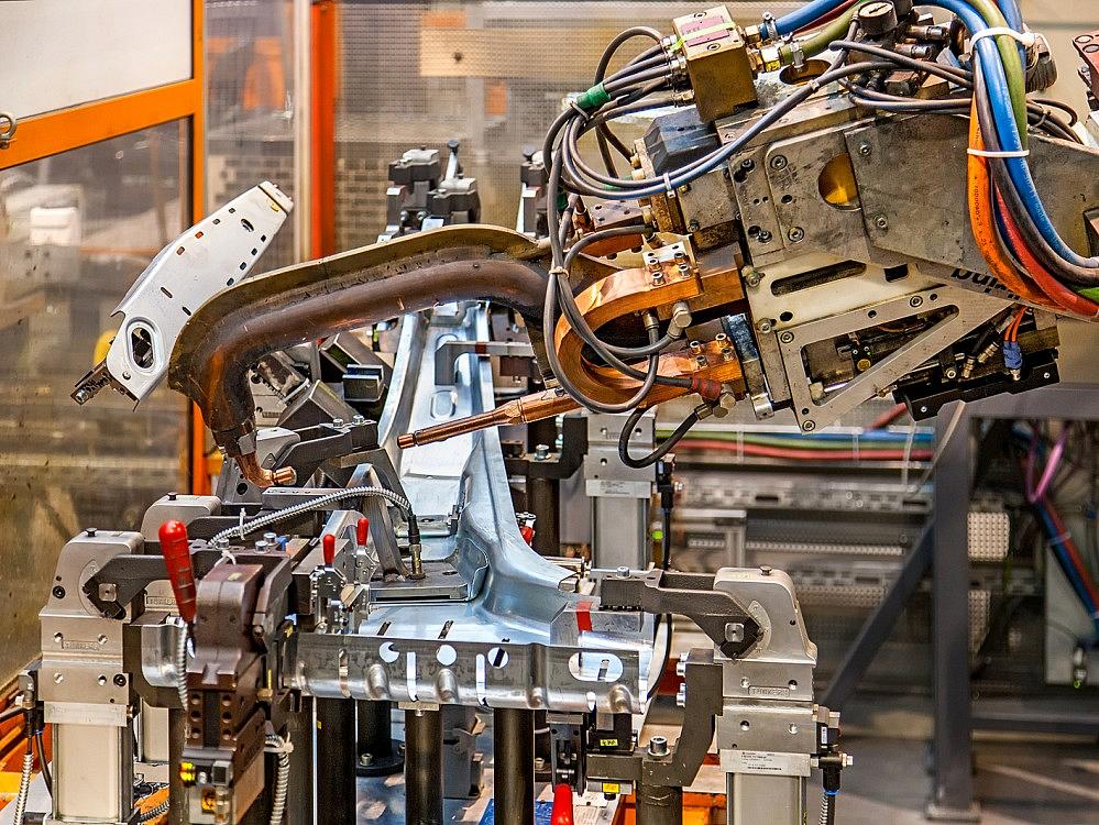 Automatisierte Fertigung von Baugruppen – Schweißroboter im Einsatz Schweißroboter bearbeitet metallische Bauteile in der automatisierten Baugruppenfertigung